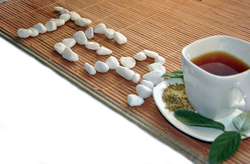 cup of green tea with white rocks text