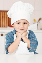 Portrait of a little chef hat and apron in the kitchen