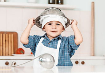 little boy plays a chef cooking utensils