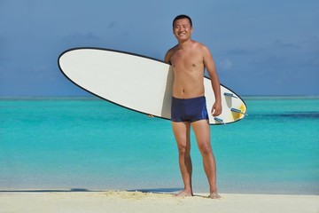 Man with surf board on beach