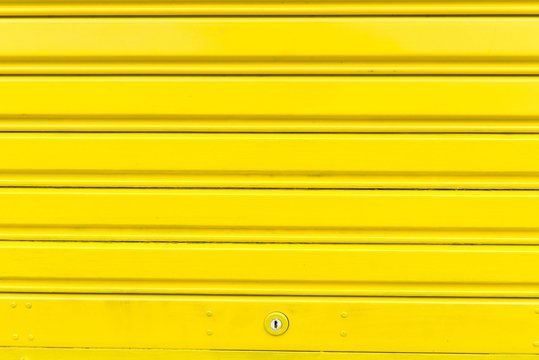 Bright yellow metal sliding door with key hole
