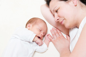 mother watching her month old son sleeping in bed