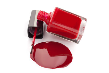 Red nail polish bottle with spilled varnish