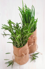 bunch of fresh rosemary and chives on wooden table
