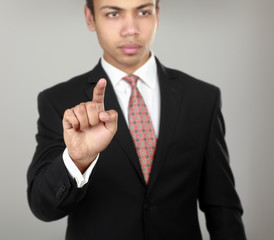 A businessman showing something isolated on grey  background