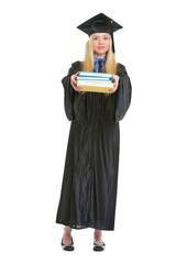 Full length portrait of woman in graduation gown giving books