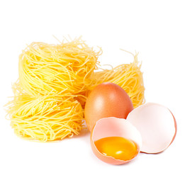 Several eggs and pasta on a white