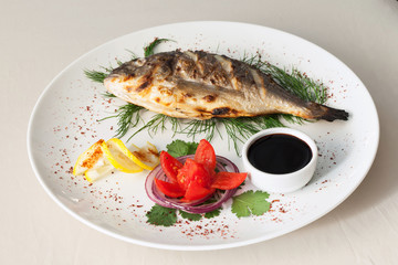 Grilled fish with tomato, herbs, onions and lemon