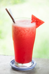 Red water melon fruit juice frappe with green bokeh background