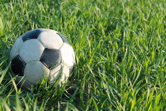 Alter vergessener Fußball im Gras