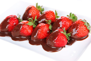 Strawberry dipped in chocolate fondue isolated on white