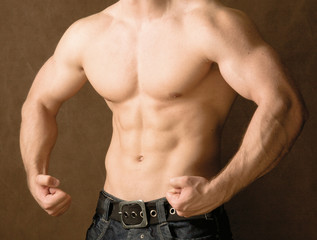 Fototapeta na wymiar Muscular man, isolated on brown background