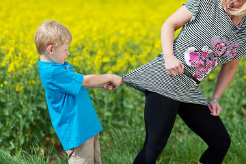 kleiner junge zieht an mama