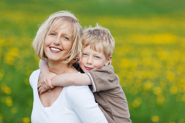 mutter und sohn gehen über blumenwiese