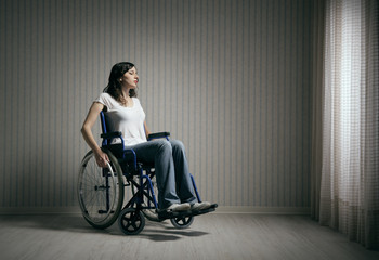 Naklejka na ściany i meble Sad woman sitting on wheelchair
