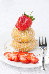 cheese pancakes with fresh strawberries on a plate vertical