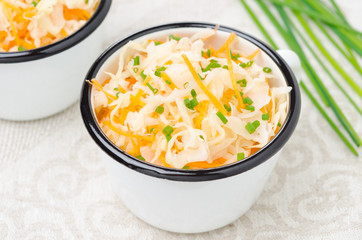 salad of pickled cabbage with carrots and green onions close-up
