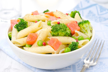 salad with pasta, salmon, broccoli, green peas in a bowl