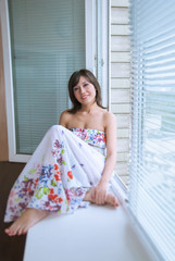 Portrait of charming girl  sitting on windowsill