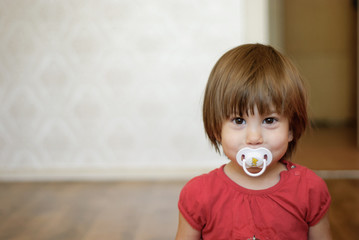 girl with a soother in her mouth