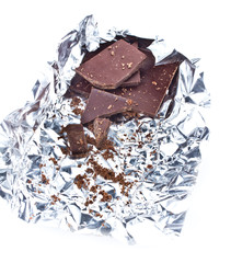 Chocolate pieces crumpled in foil on white background
