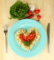 Cooked spaghetti carefully arranged in  heart shape and topped