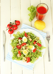 Caesar salad on white plate, on color wooden background