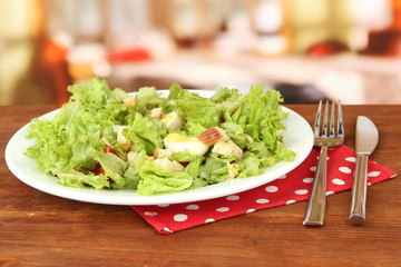 Caesar salad on white plate, on bright background