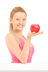 Young smiling female holding a red apple