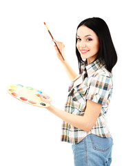 Beautiful young woman painter with brushes and palette at work,