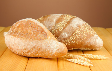 Composition with bread on wooden table, on color background