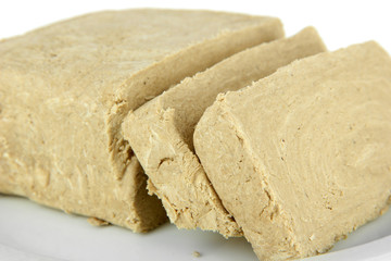 Tasty halva on plate isolated on white