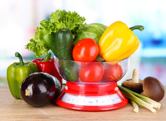 Fresh vegetables in scales on table in kitchen