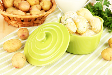 Tender young potatoes with sour cream and herbs in pan