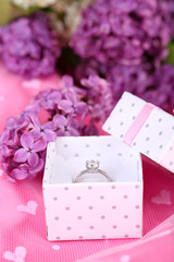 Fototapeta na wymiar Beautiful box with wedding ring on purple background