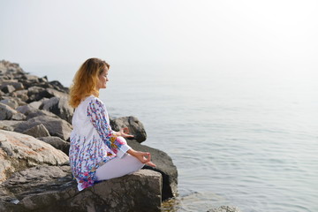 Meditation, Woman on rocky beach in yoga pose