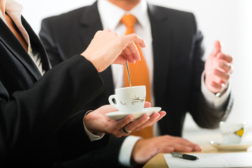 businesspersons in business office drinking coffee
