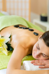 Obraz na płótnie Canvas woman having wellness hot stone massage