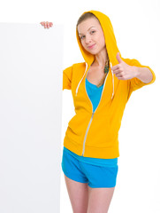 Teenager girl showing blank billboard and thumbs up