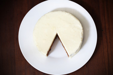 Cake with cream cheese icing, cut and piece missing