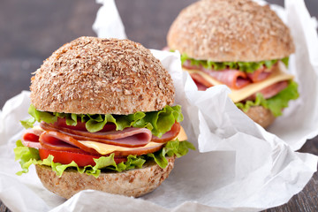 Sandwich with bacon and vegetables on wooden table