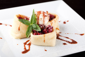 Rolled pancakes with cherry and ice cream