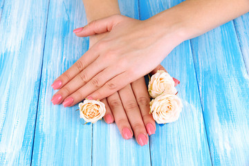 Woman hands with pink manicure and flowers,