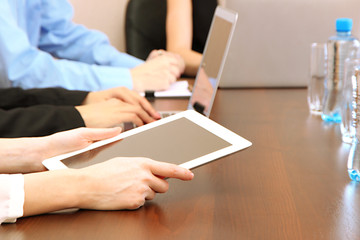 Female hands with digital tablet on office background.