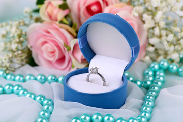 Roses and a ring on a white cloth