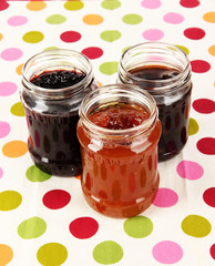 Tasty jam in banks on table