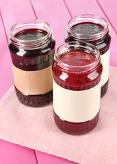 Tasty jam in banks on table