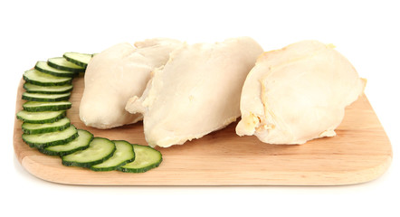 Boiled chicken breast on wooden cutting board isolated on white