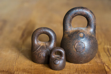 Three small calibration weights on wooden background