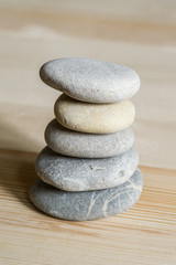 Fototapeta na wymiar Five spa zen stones stacked on a wood background